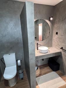 a bathroom with a toilet and a sink and a mirror at Casa 26 in Olhão +35 photos