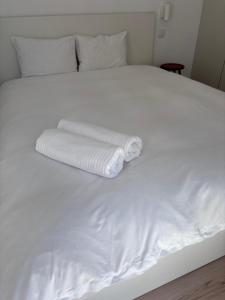 a white bed with two folded towels on it at Casa 26 in Olhão