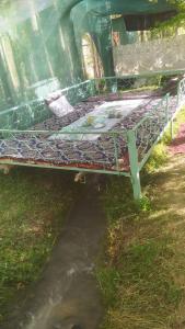 a bed with a metal frame in the grass at Kyzilnavr in Baysun