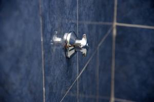 a silver shower valve in a blue tiled wall at The Premier Comfort in Nairobi +63 photos