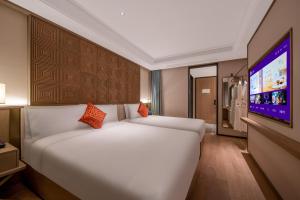 a bedroom with a large bed and a flat screen tv at Manxin Hotel Nanjing Mufu Mountain in Nanjing +49 photos