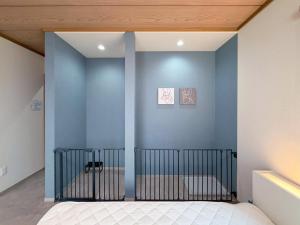 a bedroom with a blue wall with a crib at KUON Onomichi - クオン尾道 in Onomichi