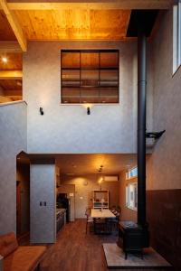 an open living room with a fireplace in a house at Kominka Guesthouse SENTŌ in Yakumo