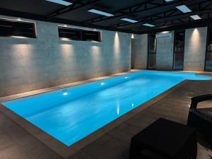 a large swimming pool with blue lighting in a building at Arinest Villa with heated pool, 20 min from Yerevan in Elar