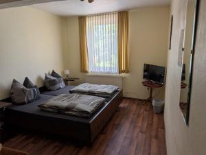 a bedroom with two beds and a television at Stadt Hamburg in Lenzen