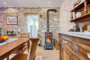 a kitchen with a wood stove in a room at Vila Leonarda with Terrace and Garden - Happy Rentals in Miren