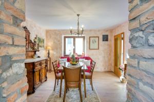 a dining room with a table and chairs and a stone wall at Vila Leonarda with Terrace and Garden - Happy Rentals in Miren
