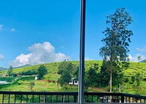 a view of a green hill from a window at Lake Infinity Luxury Condos in Nuwara Eliya +5 photos