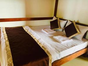 a bed with two pillows on it in a room at Lake Infinity Luxury Condos in Nuwara Eliya