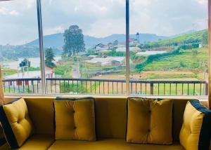 a couch sitting in front of a large window at Lake Infinity Luxury Condos in Nuwara Eliya
