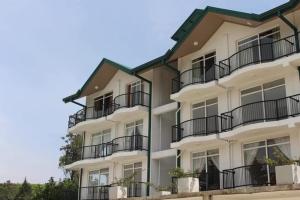 a white apartment building with balconies on it at Lake Infinity Luxury Condos in Nuwara Eliya