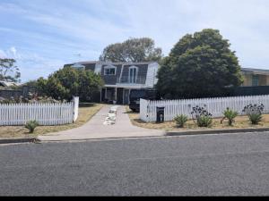 a white fence in front of a house at The Elephants Nest in Victor Harbor
