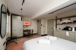 a bedroom with a white bed and a table at GuestReady - The Euston in London +27 photos