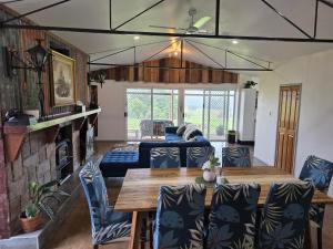 a living room with a wooden table and chairs at Hideaway Falls Rustic Farm House in Ravenshoe +77 photos