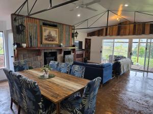 a dining room with a wooden table and chairs at Hideaway Falls Rustic Farm House in Ravenshoe