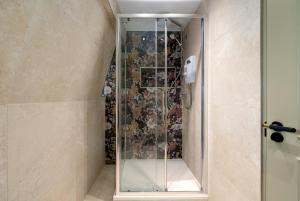 a shower with a glass door in a bathroom at GuestReady - The Euston in London