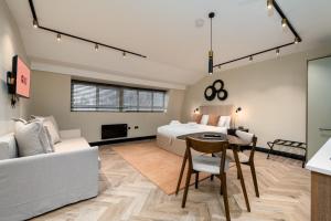 a bedroom with a bed and a table and a couch at GuestReady - The Euston in London