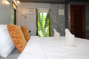 a bedroom with a white bed with white pillows at Charlotte place in El Nido