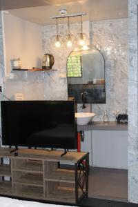 a bathroom with a tv and a sink and a mirror at Charlotte place in El Nido
