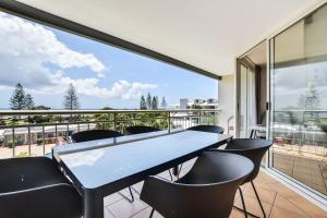 a dining room with a table and chairs on a balcony at Alex Beach Resort 3BR Apt 428 in Alexandra Headland
