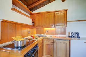 a kitchen with wooden cabinets and a stove top oven at La Capannina Lake & Mountain Views - Happy Rentals in Cimo