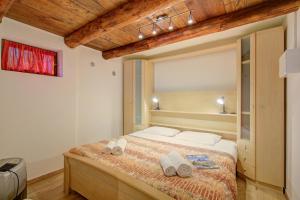 a bedroom with a bed with towels on it at La Capannina Lake & Mountain Views - Happy Rentals in Cimo