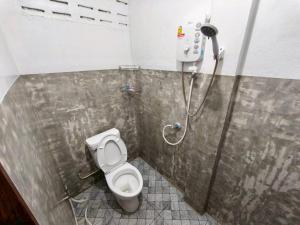 a bathroom with a toilet in a stall at Pornaree Hotel in Ban Pak Ba Ra