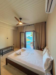 a bedroom with a bed and a ceiling fan at Summer Palace Evia in Petriaí +165 photos