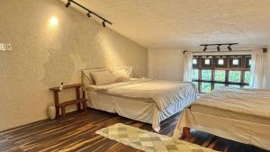 a bedroom with two beds and a window at Đồi Ông Thoại Cottage in Bảo Lộc
