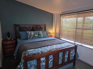 a bedroom with a large bed and a window at Hideaway Falls Rustic Farm House in Ravenshoe