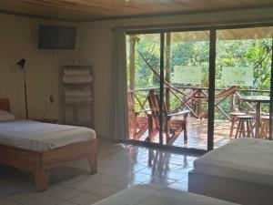 a bedroom with a bed and a balcony with a patio at Drake Bay Corcovado The Monkey Trail in Drake