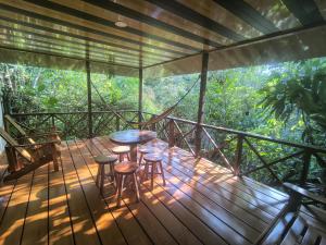a wooden deck with stools and a table on it at Drake Bay Corcovado The Monkey Trail in Drake