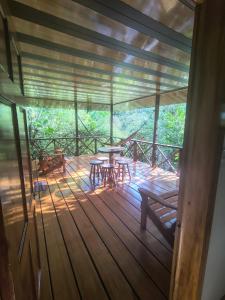 a wooden deck with a table and benches on it at Drake Bay Corcovado The Monkey Trail in Drake