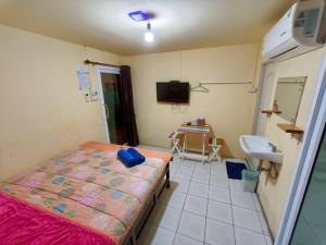 a small room with a bed and a sink in it at Pornaree Hotel in Ban Pak Ba Ra