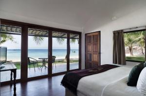 a bedroom with a bed and a view of the ocean at Mali Resort Pattaya Beach Koh Lipe in Ko Lipe