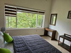 a bedroom with a bed and a large window at Sunrise Staycation in Katuneriya