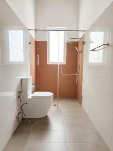 a bathroom with a toilet and a glass shower at Sunrise Staycation in Katuneriya +17 photos