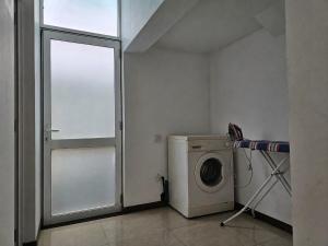 a laundry room with a washing machine and a window at Sunrise Staycation in Katuneriya