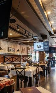 a restaurant with tables and chairs and a large screen at Antika Hotel in Batumi +16 photos