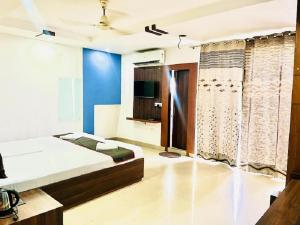 a bedroom with a bed and a tv in a room at IR Luxuria Hotel, Guwahati in Guwahati