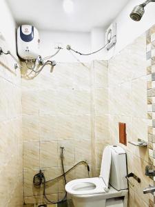 a bathroom with a toilet and a camera on the wall at IR Luxuria Hotel, Guwahati in Guwahati