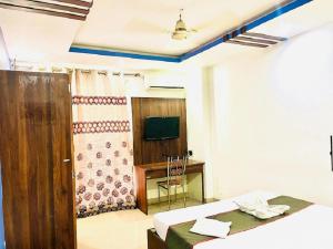 a room with two beds and a television in it at IR Luxuria Hotel, Guwahati in Guwahati +34 photos