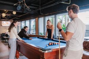 a group of people standing around a pool table at Bunk Surfers Paradise 18-35 Backpacker Hostel in Gold Coast