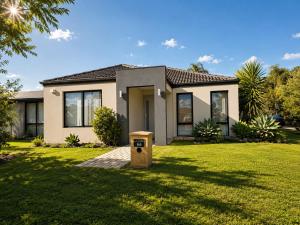 a house in a yard with a recycling box in front of it at Modern oasis in Perth
