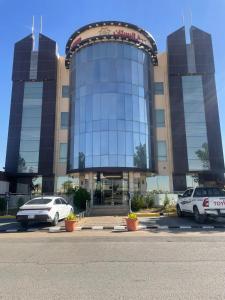 a large building with cars parked in front of it at فندق قمة البستان الرفاع in Arar