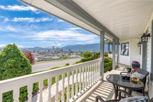 a balcony with a table and chairs and a view of a city at KnoxPeace BnB in Kelowna