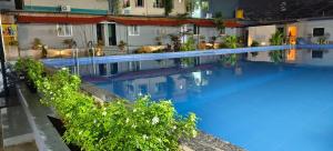 a large swimming pool with blue water in a building at Himalaya Pool & Resort Hotel in Tirupati