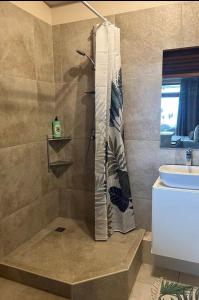 a bathroom with a shower and a sink at Suite confortable avec vue imprenable in Punaauia