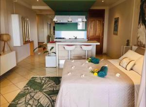 a room with a kitchen and a bed with a toy on it at Suite confortable avec vue imprenable in Punaauia