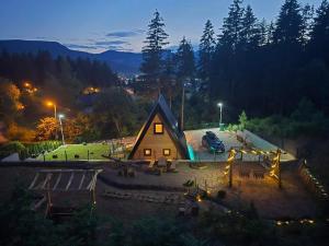 a wooden cabin with a playground in a park at night at Vikendica Villa Marija Pale in Pale